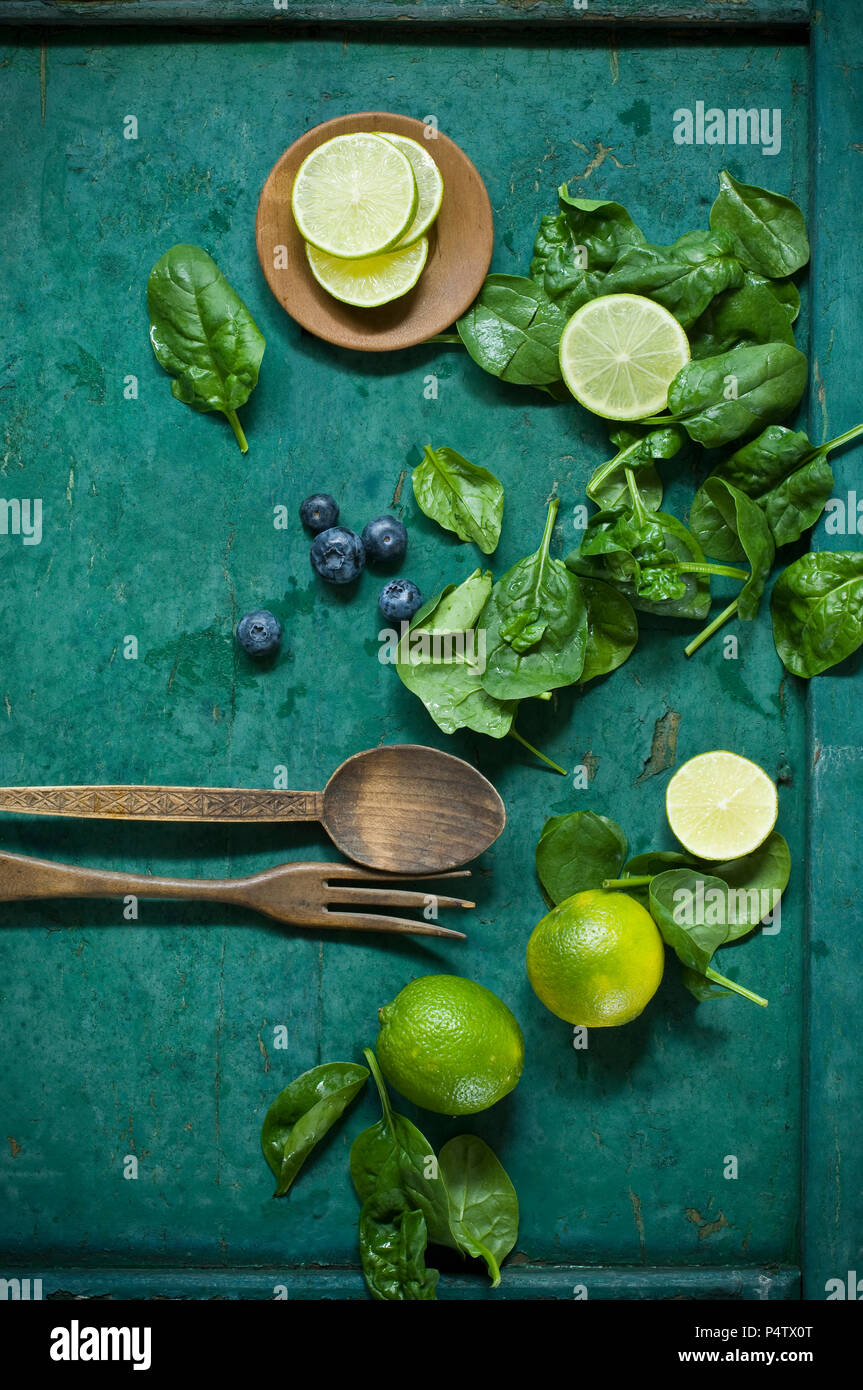 Salad ingredients and salad cutlery on green ground Stock Photo