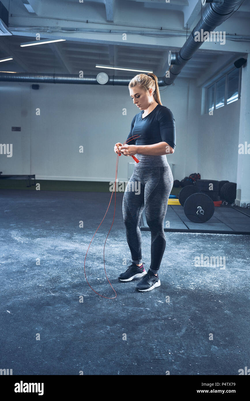 Woman adjusting jumping rope before exercise at gym Stock Photo