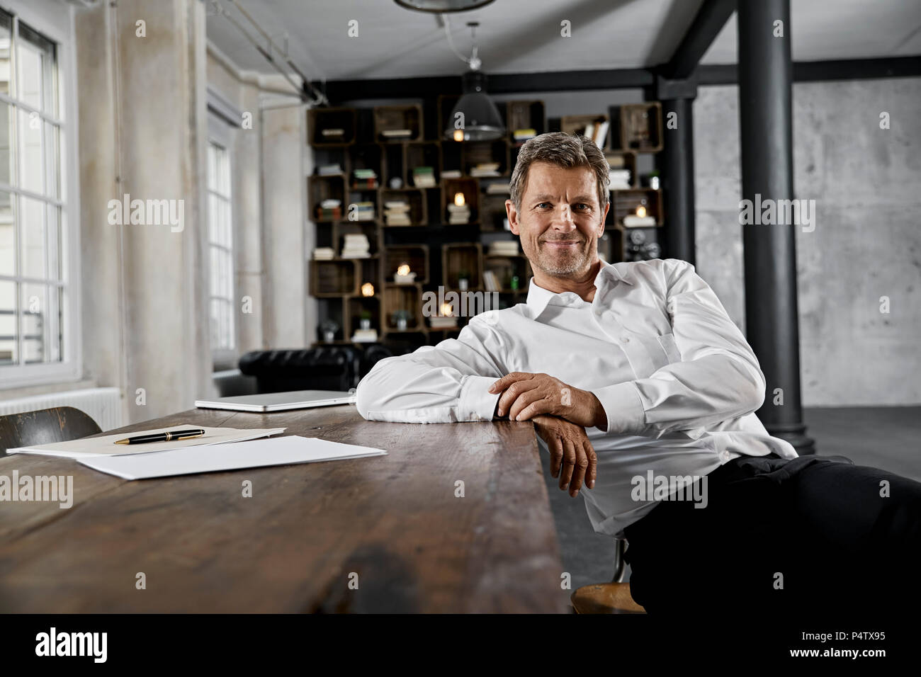 Portrait of mature businessman in loft office Stock Photo