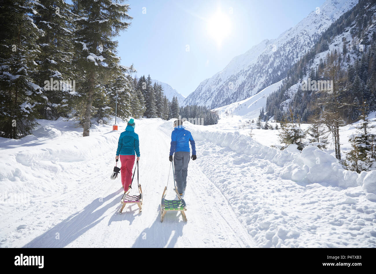 Couple with sledge walking in snow-covered landscape Stock Photo