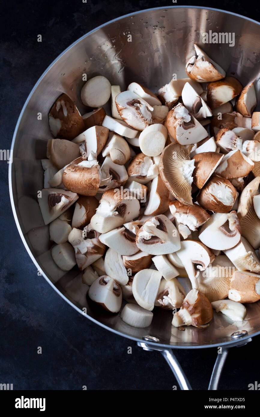 Sliced Crimini Mushrooms in stainless steel pan Stock Photo Alamy