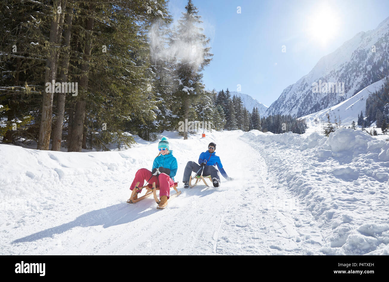 Couple sledding in snow-covered landscape Stock Photo