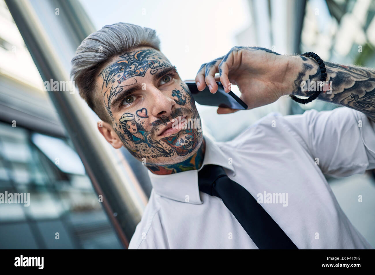 Young businessman with tattooed face, talking on he phone Stock Photo -  Alamy