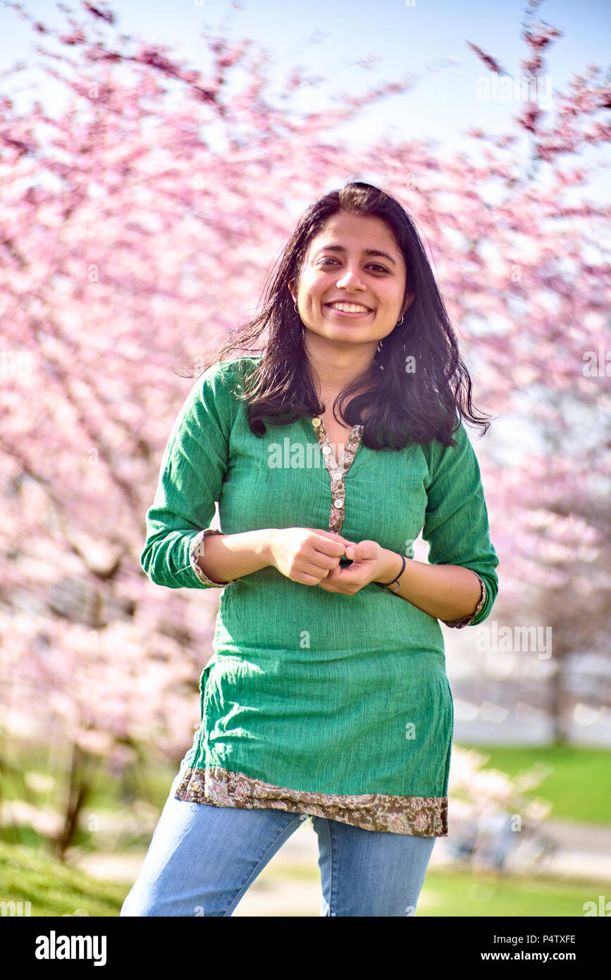 Portrait of happy young woman in a park at cherry blossom tree Stock ...