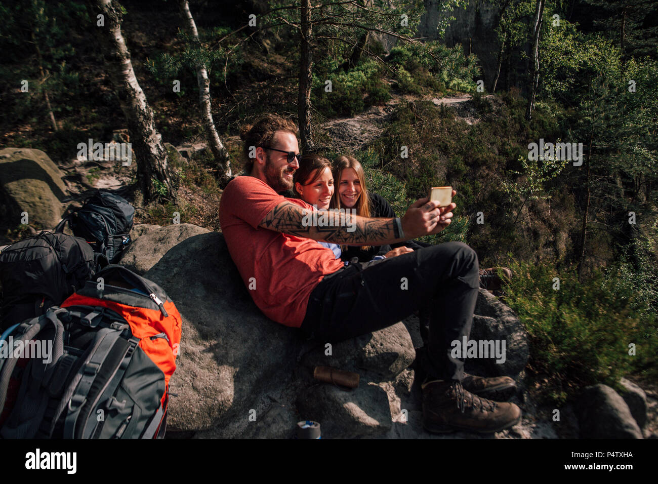 Germany, Saxony, Elbe Sandstone Mountains, friends on a hiking trip having a break taking a selfie Stock Photo