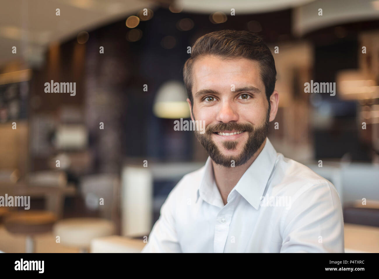 Portrait of smiling young businessman in a cafe Stock Photo