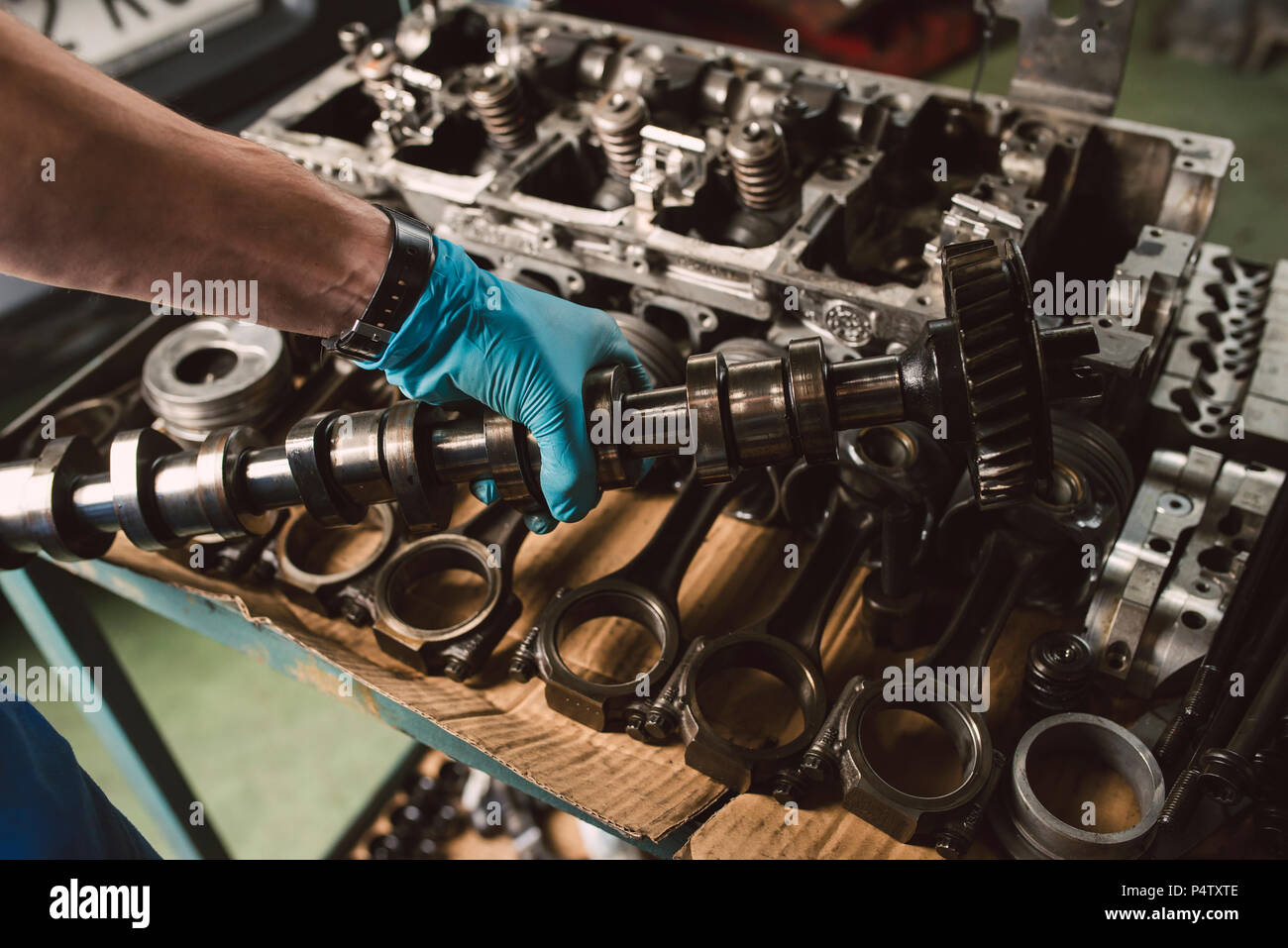 Close-up of mechanic holding the crankshaft of the engine of a car in a workshop Stock Photo