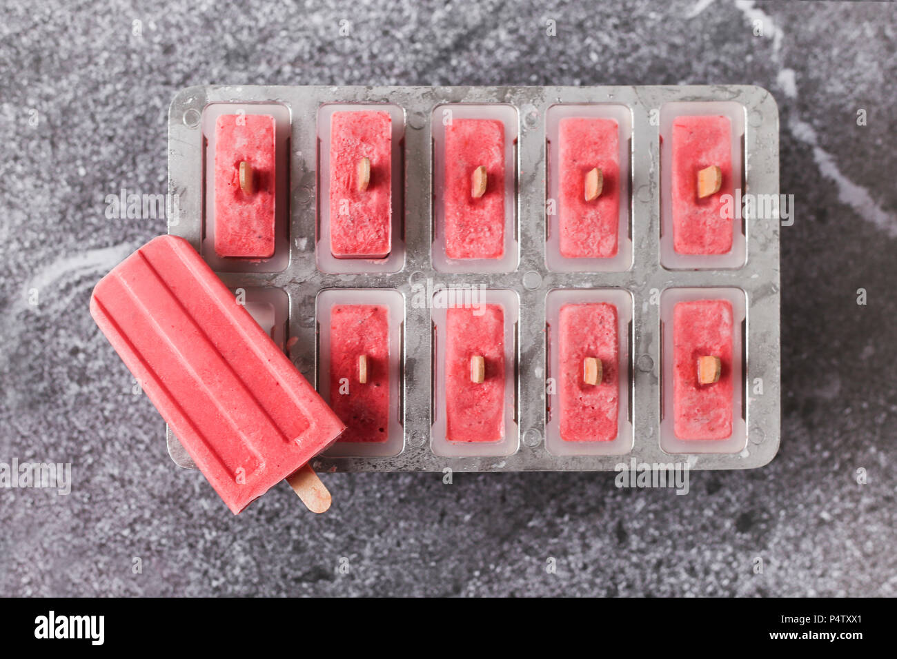 Homemade strawberry ice lollies in tray Stock Photo