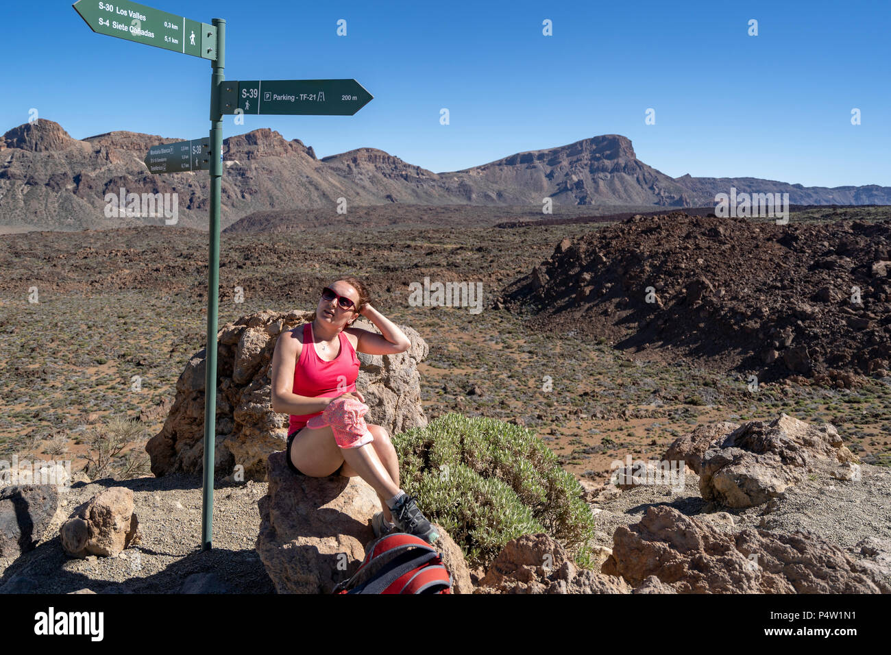 Female tourist enjoys the views of Los Roques de Garcia in Las Canadas National park, Teide Mountain, UNESCO Heritage Site, Tenerife, Canary Islands Stock Photo
