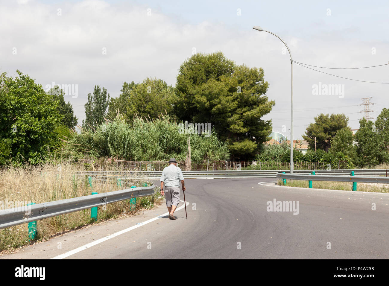 Valencia, Spain, man with walking stick on country road on the outskirts Stock Photo