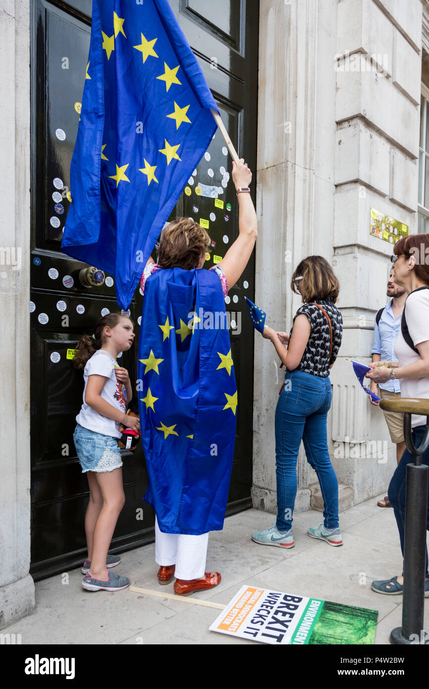 London, UK. 23 June 2018.Anti-Brexit march and rally for a People's Vote in Central London. Protesters putting anti-brexit stickers on the front door of the Cabinet Office. Stock Photo