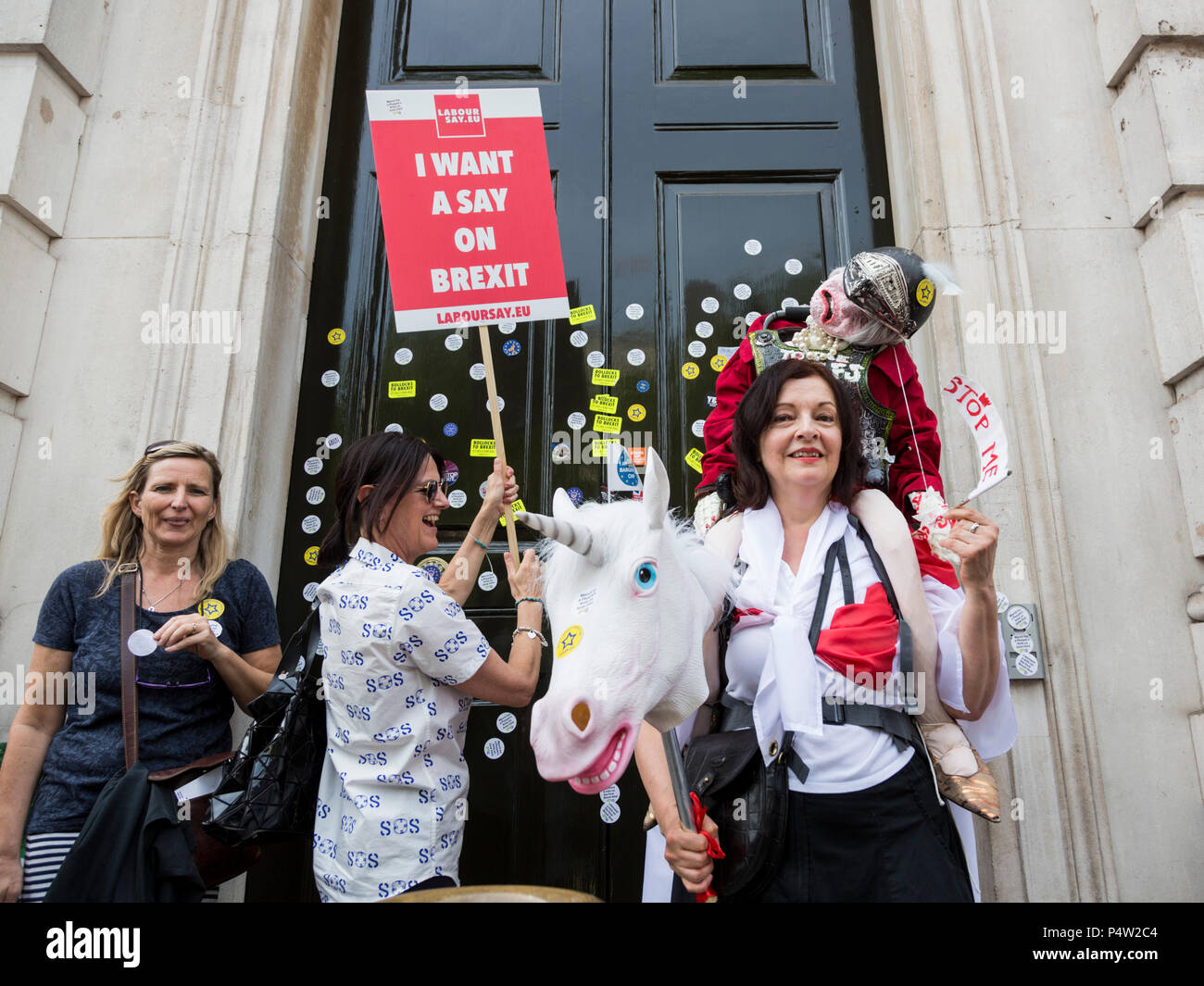 London, UK. 23 June 2018.Anti-Brexit march and rally for a People's Vote in Central London. Protesters putting anti-brexit stickers on the front door of the Cabinet Office. Stock Photo