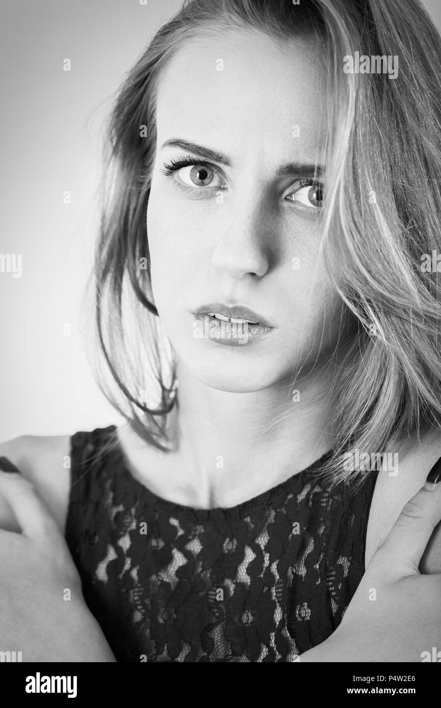 scared beautiful girl looking at camera, embraced herself, monochrome Stock Photo