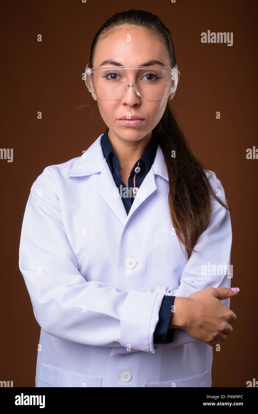 Young beautiful woman doctor wearing protective glasses against  Stock Photo