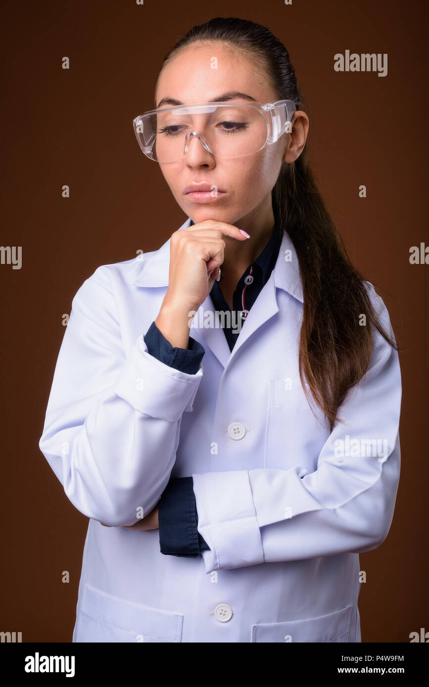 Young beautiful woman doctor wearing protective glasses against  Stock Photo