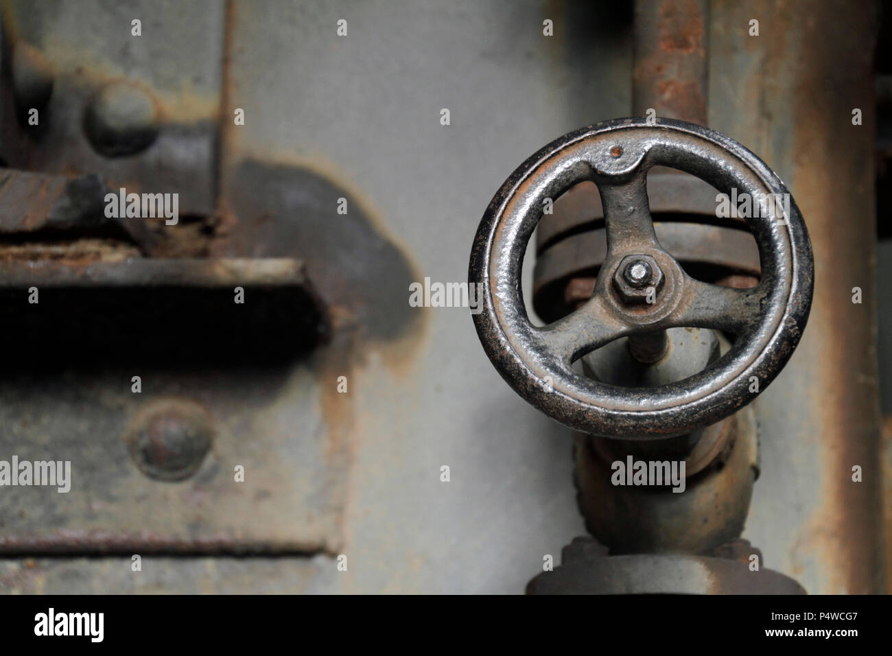 Iron valve handle in abandoned steel mill Stock Photo