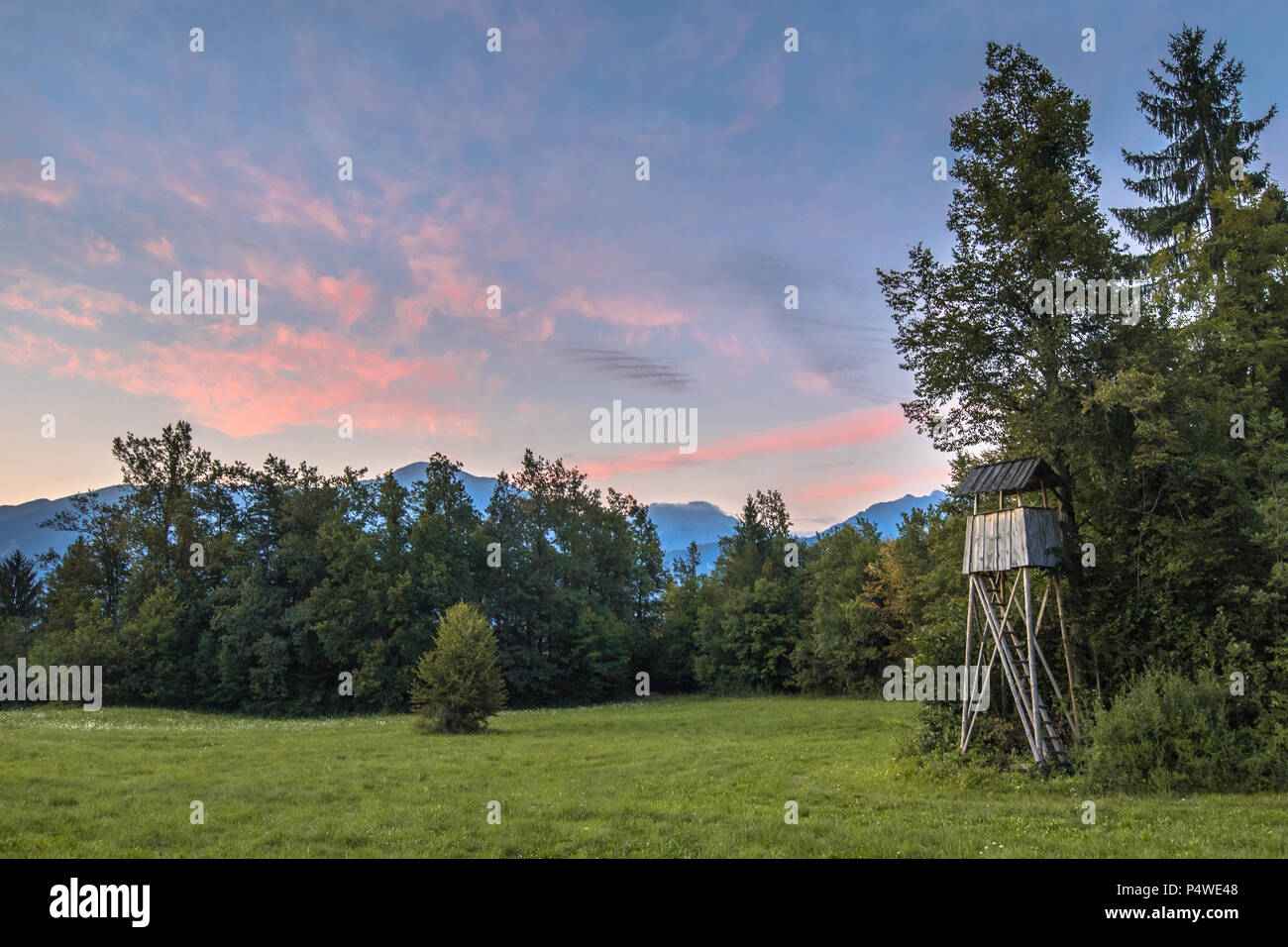 Slovenian landscape at sunset with observation hide tower for hunting Stock Photo