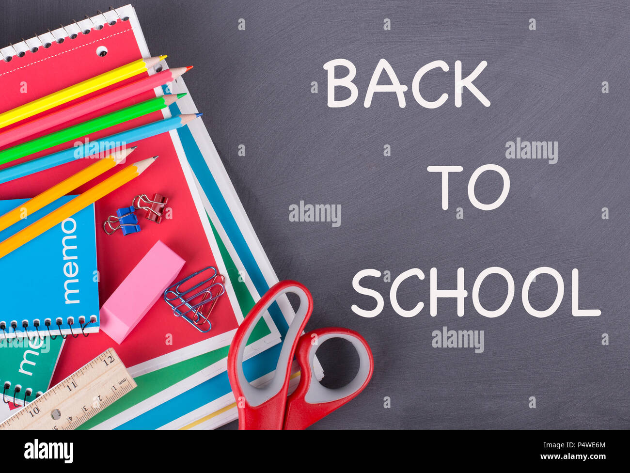 School supplies on a chalkboard background with BACK TO SCHOOL text Stock Photo