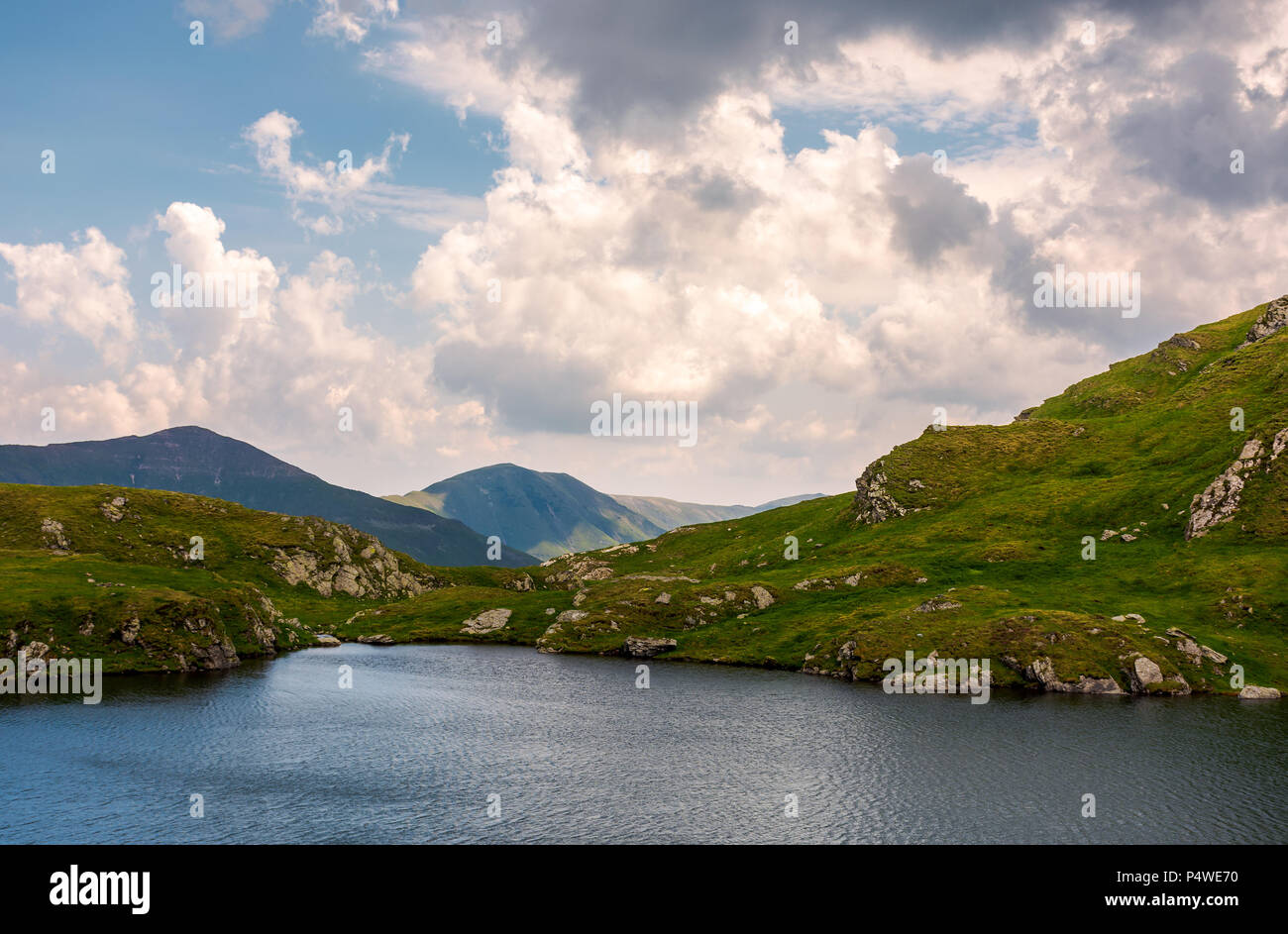 gorgeous cloudscape over the Capra lake. amazing Fagaras mountain ridge in the distance. Stock Photo
