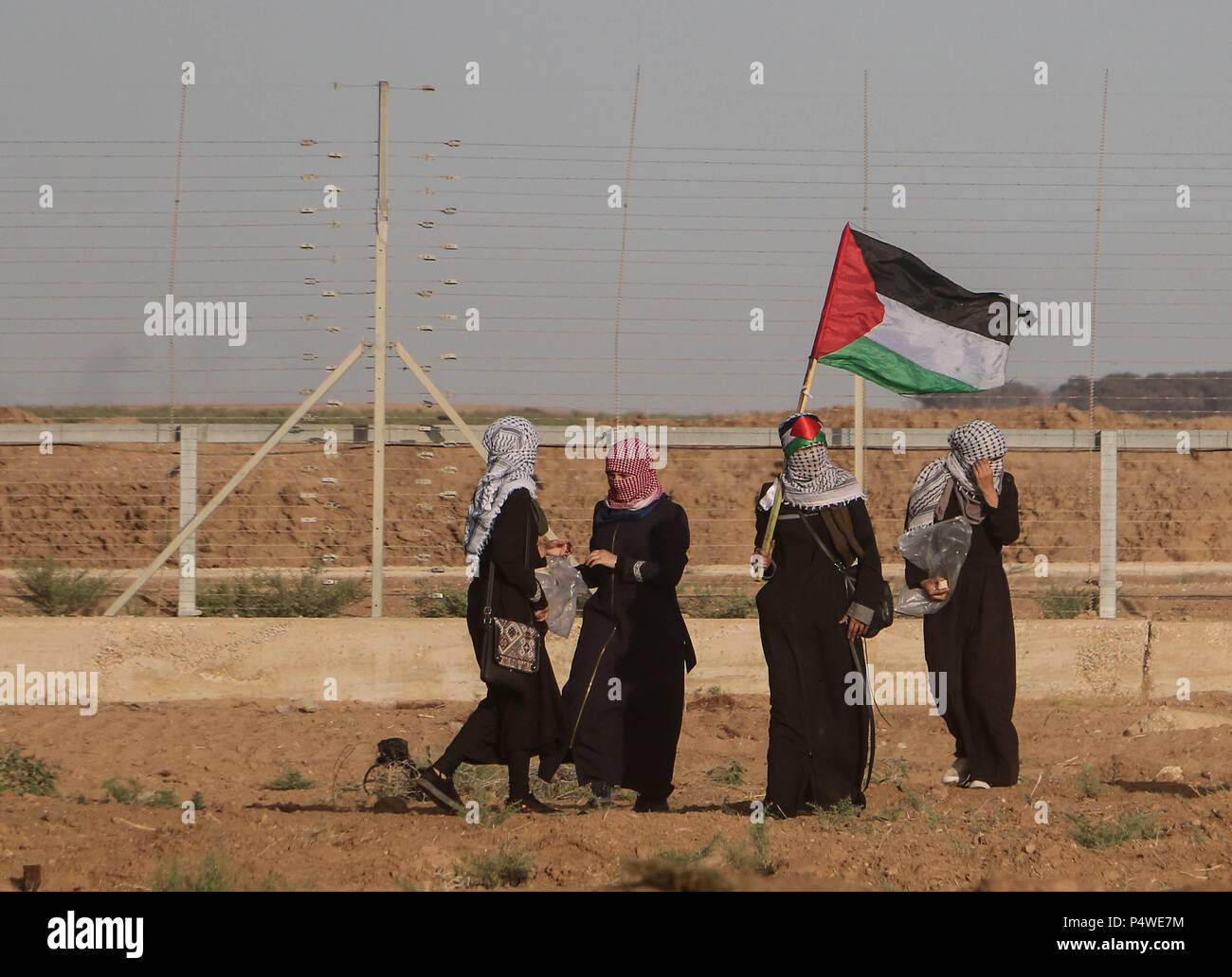 4 girls raising the flag of Palestine near the separation fence east of Gaza City. Clashes between Palestinian civilians and Israeli soldiers broke out once again at  the border of the Gaza Stripe and Isreal near the Nahal Oz site east of Gaza City. The Israeli forces injured many Palestinian civilians by firing live ammunition and tear gas canisters to the protester who are within their own territory. The Palestinians are protesting the transfer of the American Embassy to Jerusalem and the recognition of  Jerusalem as the capital of Israel by the US president Donald Trump. Stock Photo