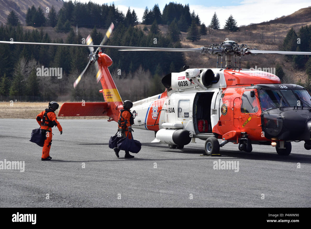 KODIAK, Alaska - Aircraft Maintenance Technicians load survival gear onto a U.S. Coast Guard MH-60T Jayhawk attached to Air Station Kodiak, Alaska prior to takeoff. Northern Edge 2017 is Alaska's premiere joint-training exercise designed to practice operations, techniques, and procedures as well as enhance interoperability among the services. Thousands of participants from all the services; Sailors, Airmen, Soldiers, Marines, and Coast Guard personnel from active duty, Reserve and National Guard units, are involved. Stock Photo