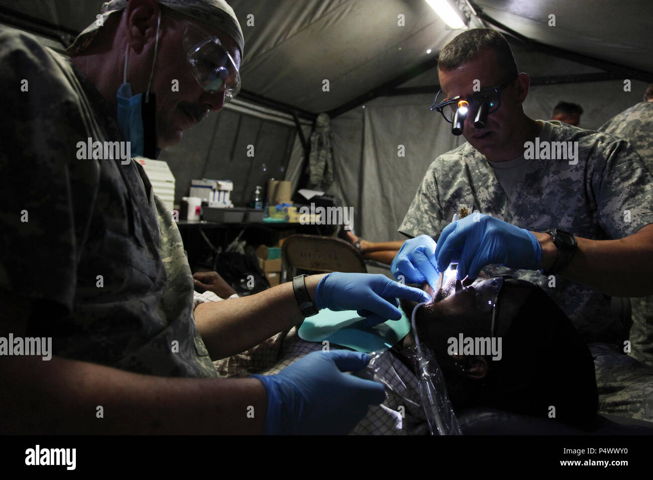 U.S. Army dental staff, with the Wyoming National Guard Medical Detachment, remove the tooth of a Belizean boy during a medical readiness event held in San Ignacio, Belize, May 09, 2017. This is the second of three medical events that are scheduled to take place during Beyond the Horizon 2017. BTH 2017 is a U.S. Southern Command-sponsored, Army South-led exercise designed to provide humanitarian and engineering services to communities in need, demonstrating U.S. support for Belize. Stock Photo