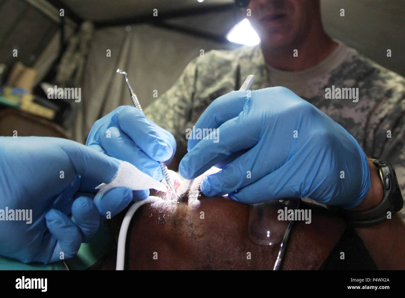 U.S. Army dental staff, with the Wyoming National Guard Medical Detachment, remove the tooth of a Belizean boy during a medical readiness event held in San Ignacio, Belize, May 09, 2017. This is the second of three medical events that are scheduled to take place during Beyond the Horizon 2017. BTH 2017 is a U.S. Southern Command-sponsored, Army South-led exercise designed to provide humanitarian and engineering services to communities in need, demonstrating U.S. support for Belize. Stock Photo