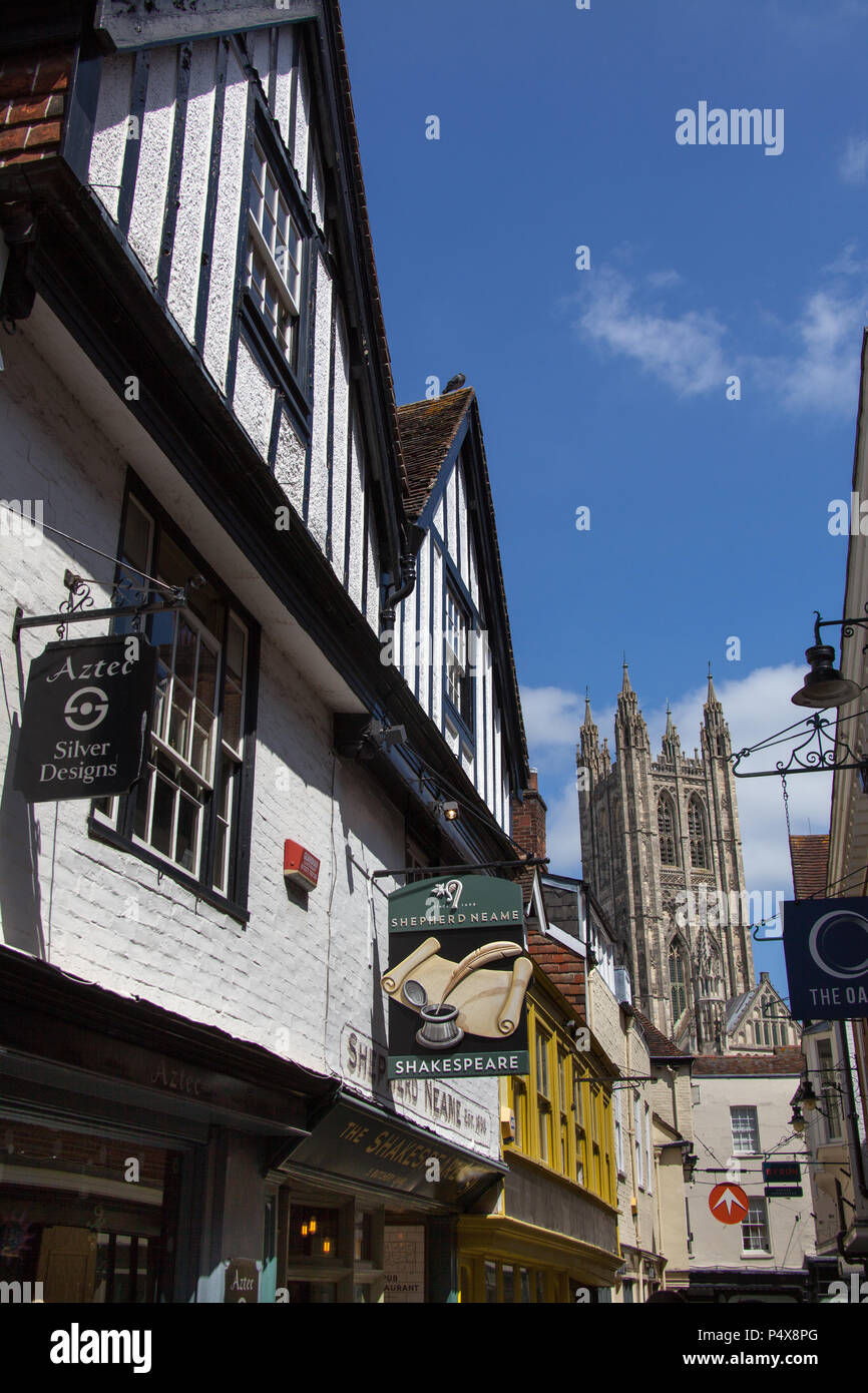 City of Canterbury, England. Shop and pub fronts on Canterbury’s Butchery Lane, with Canterbury Cathedral’s Bell Harry Tower in the background. Stock Photo