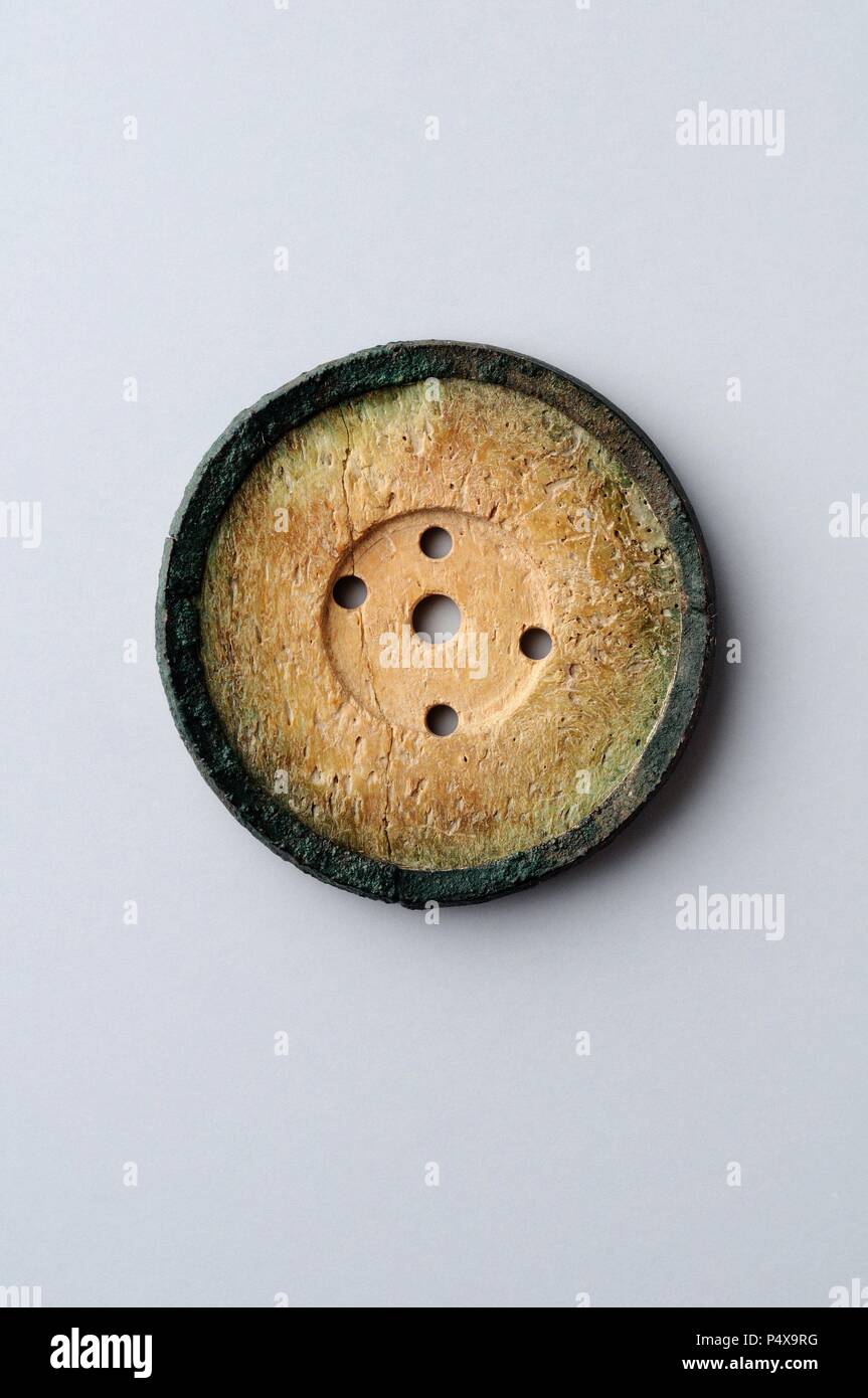 Bone Button with five holes. Diameter 1.2 cm Thickness 0, 3 cm - Medieval period from the archaeological site of the " Calle seises " in Alcalá de Henares - " Burgo de Santiuste Museum " (Madrid). SPAIN. Stock Photo