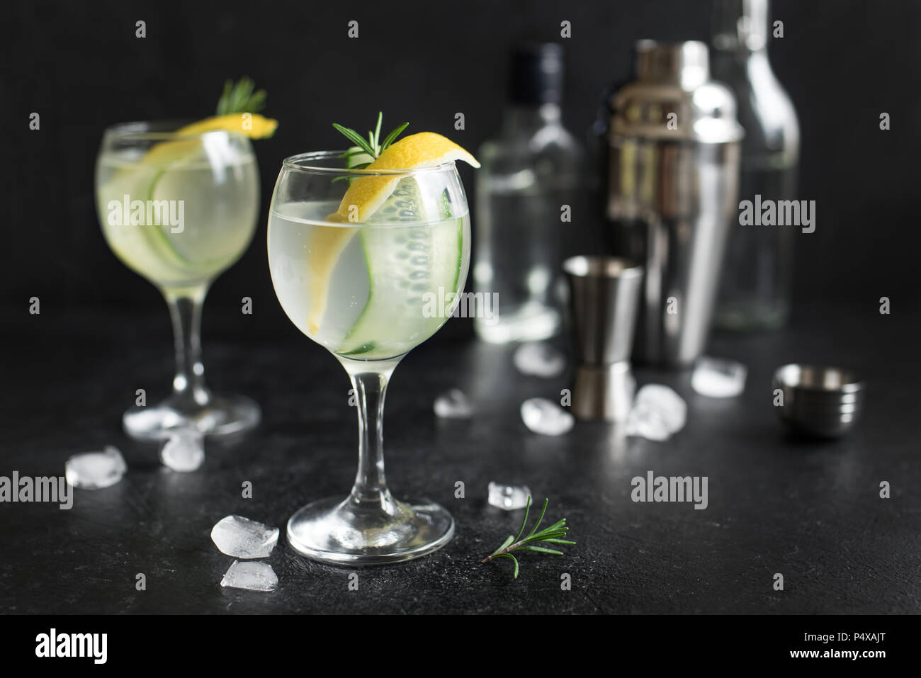 Gin fizz cocktail with lemon, cucumber, rosemary and ice. Gin tonic or gimlet on black background, copy space. Stock Photo