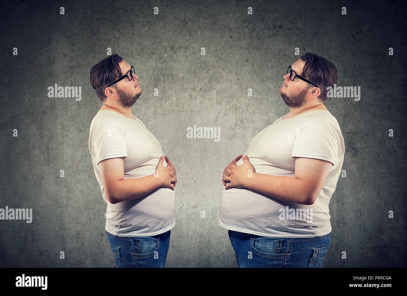 Young chubby man looking at fat himself feeling bloated. Diet and nutrition choice  healthy lifestyle concept Stock Photo