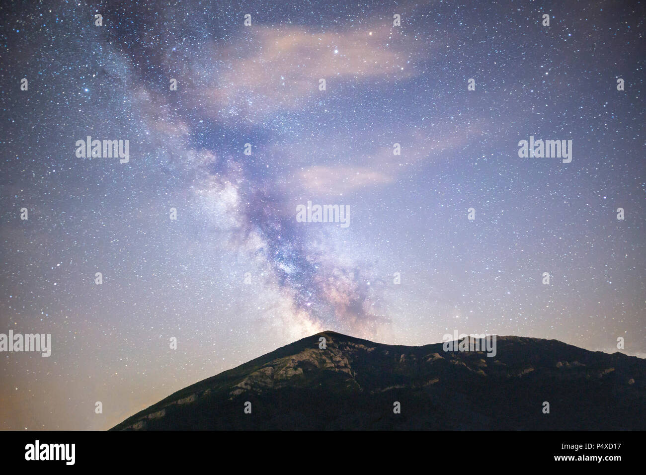 A view of the stars of the Milky Way with a mountain top in the foreground. Night sky nature summer landscape. Perseid Meteor Shower observation. Rtan Stock Photo