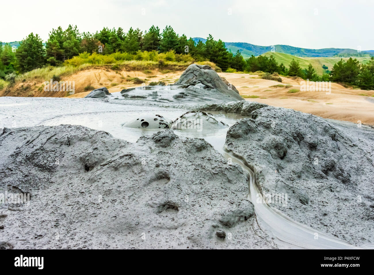 Buzau, Paclele mari, Romania: Bubbling mud, landscape with muddy volcano at sunset - landmark attraction Stock Photo