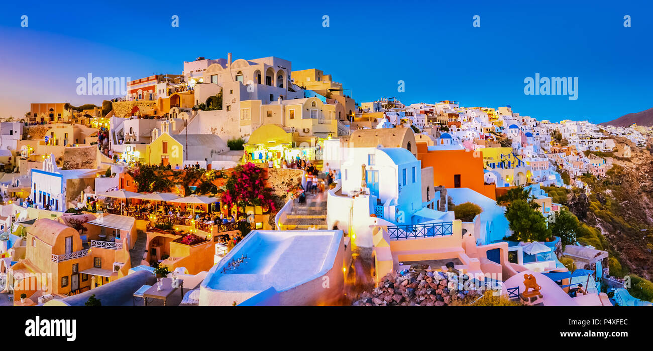 Panoramic view of Oia town, Santorini island, Greece at sunset. Traditional and famous white houses and churches  with blue domes over the Caldera, Ae Stock Photo
