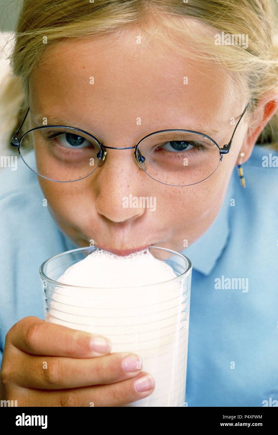 Niña de 10 años bebiendo un vaso de leche. Stock Photo