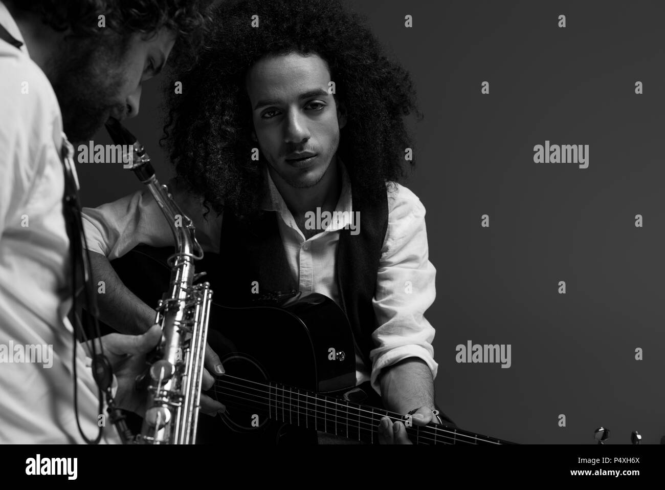 black and white shot of duet of musicians playing sax and acoustic