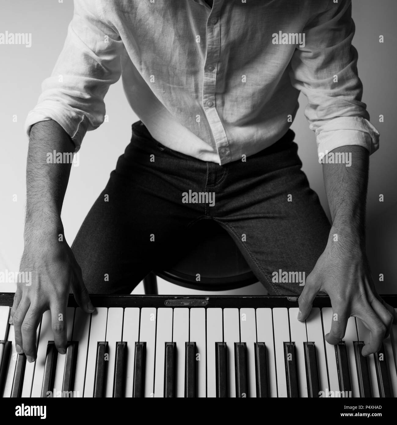 black and white cropped shot of man playing piano Stock Photo