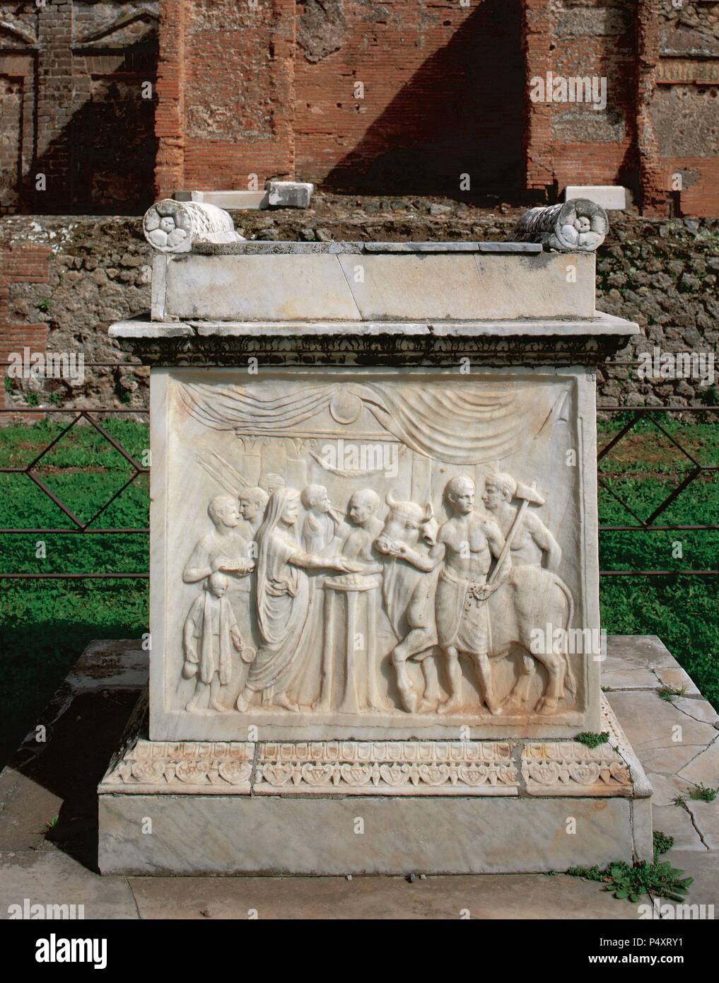 Roman Art. Pompeii. Altar of Vespasian, Temple of Vespasian (69-79 CE). The relief shows a sacrificial scene: the sacrificer and his aide bring the sacrificial bull, while the priest, a veil over his head, pours the libation over a tripod. Archaeological Site. Pompeii. Italy. Stock Photo