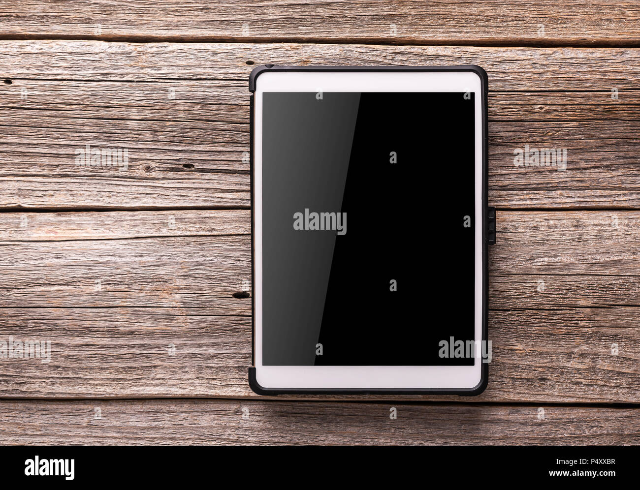 White tablet pc on old wood table background. Stock Photo