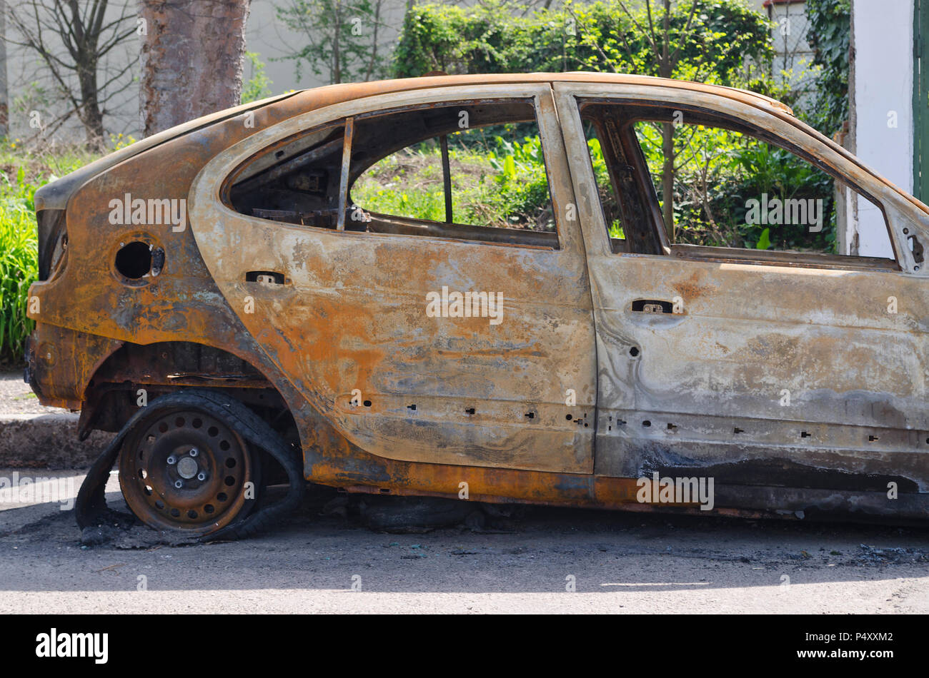 Burned car parked on the street side view - Close up photo of a burned out car Stock Photo