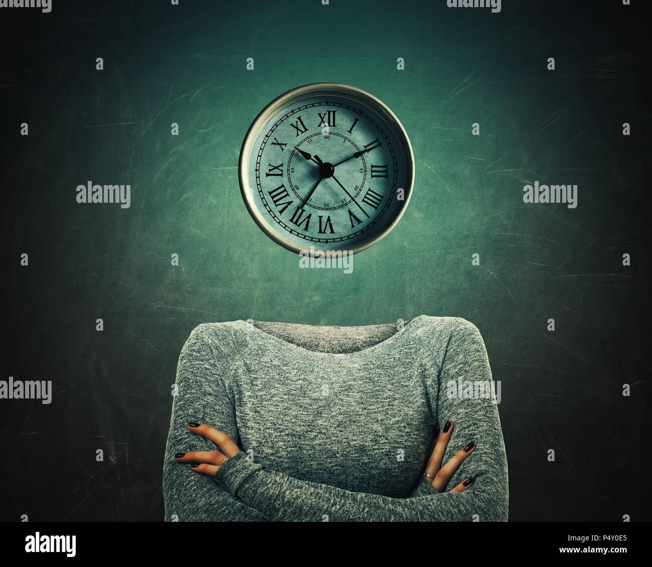 Surreal image of a confident woman with crossed hands and a clock instead of head over blackboard background. The concept of time in educational proce Stock Photo