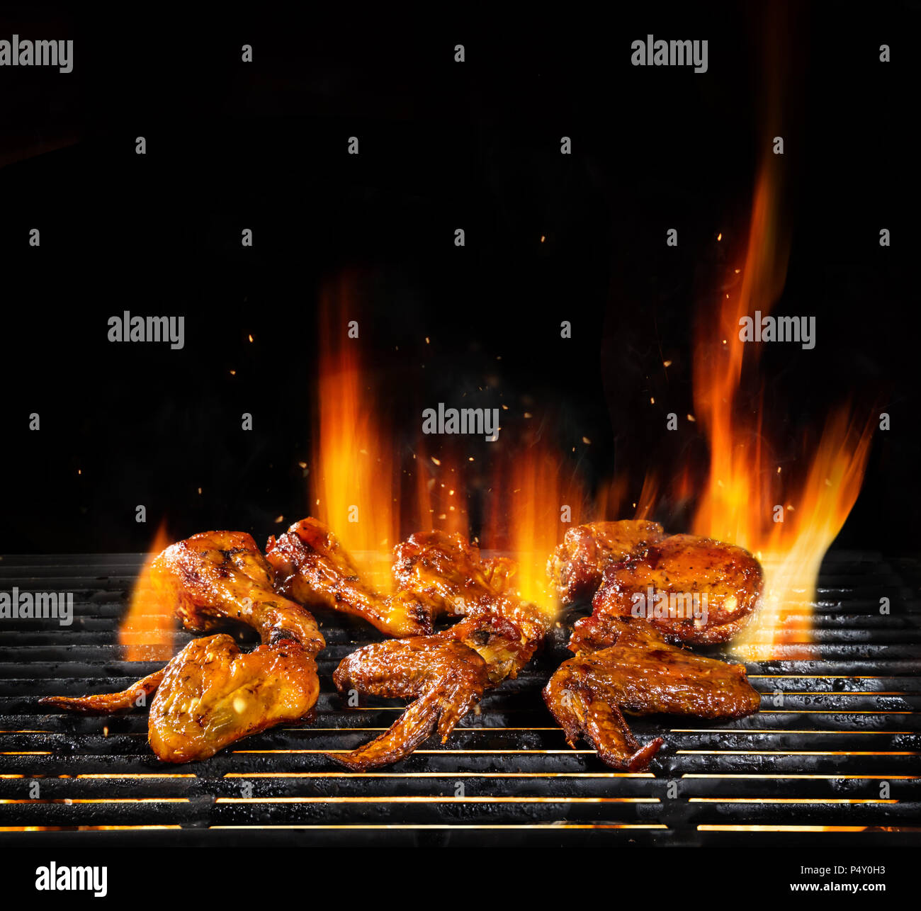 Delicious pieces of chicken meat on grill with Fire flames. Isolated on  black background. Barbecue and grilling. Very high resolution image Stock  Photo - Alamy