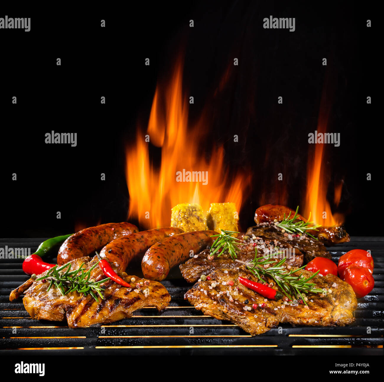 Delicious pieces of meat on grill with Fire flames. Isolated on black  background. Barbecue and grilling. Very high resolution image Stock Photo -  Alamy