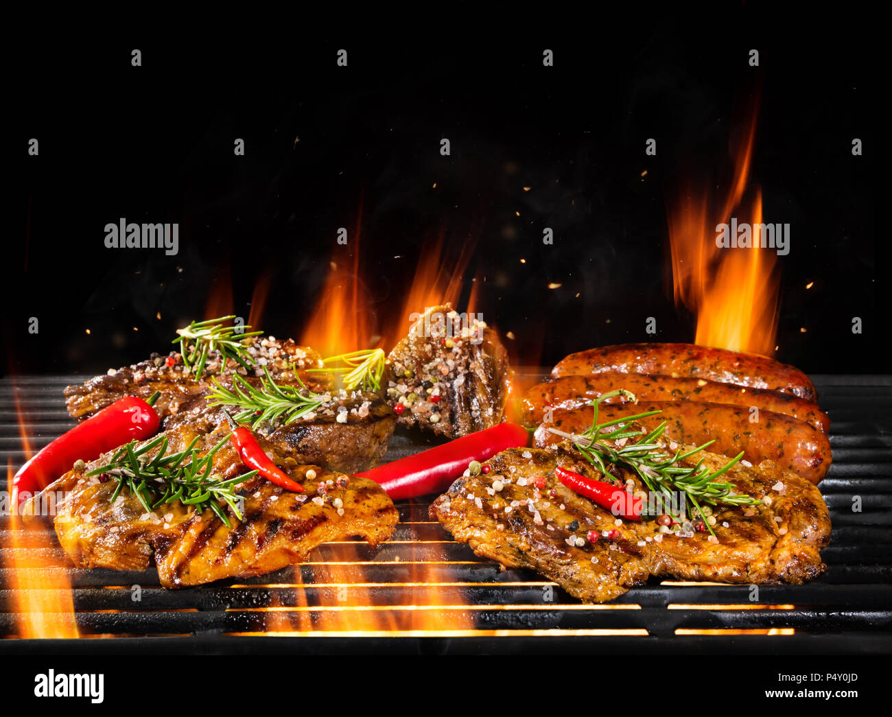 Delicious pieces of meat on grill with Fire flames. Isolated on black  background. Barbecue and grilling. Very high resolution image Stock Photo -  Alamy