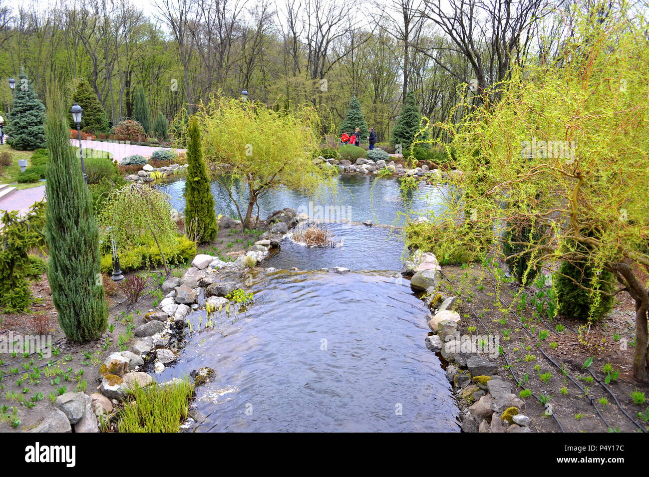 An artificial waterfall in a city park in early spring Stock Photo - Alamy