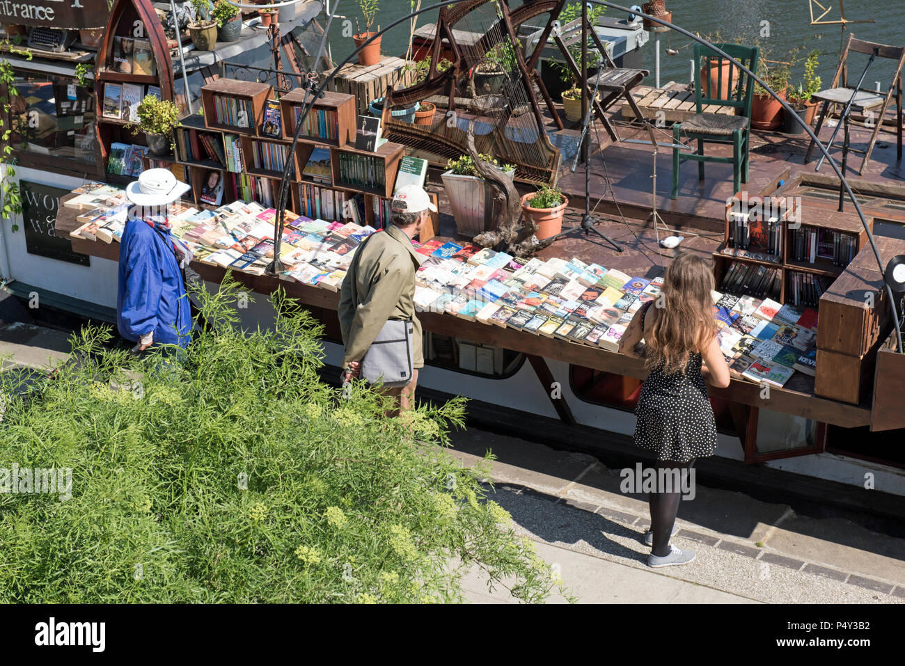 People looking at books for sale on a boat, Regent's Canal Kings Cross London England Britain UK Stock Photo