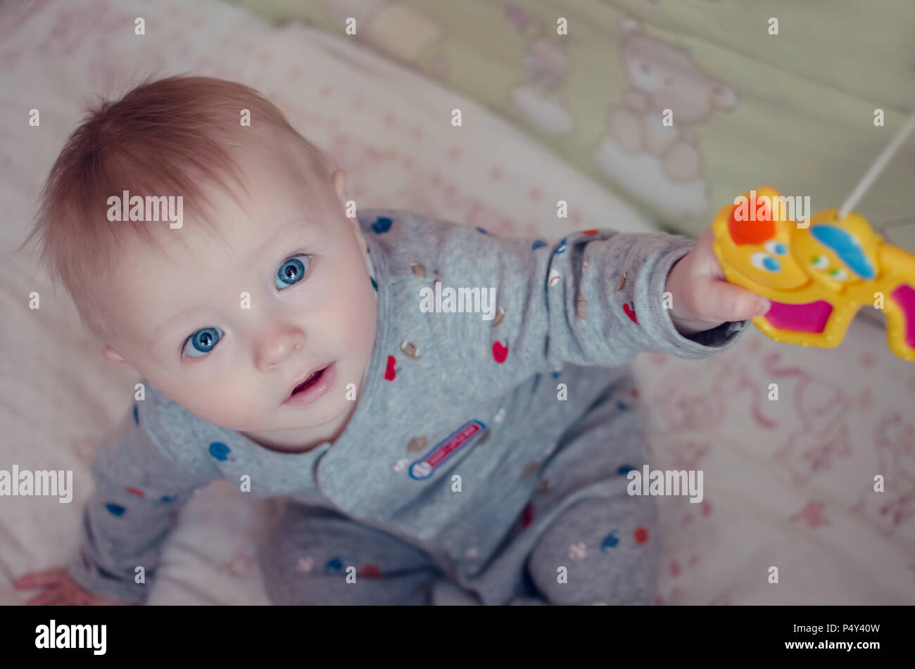 Beautiful Baby Boy With Big Blue Eyes Sitting And Plaing With Crib
