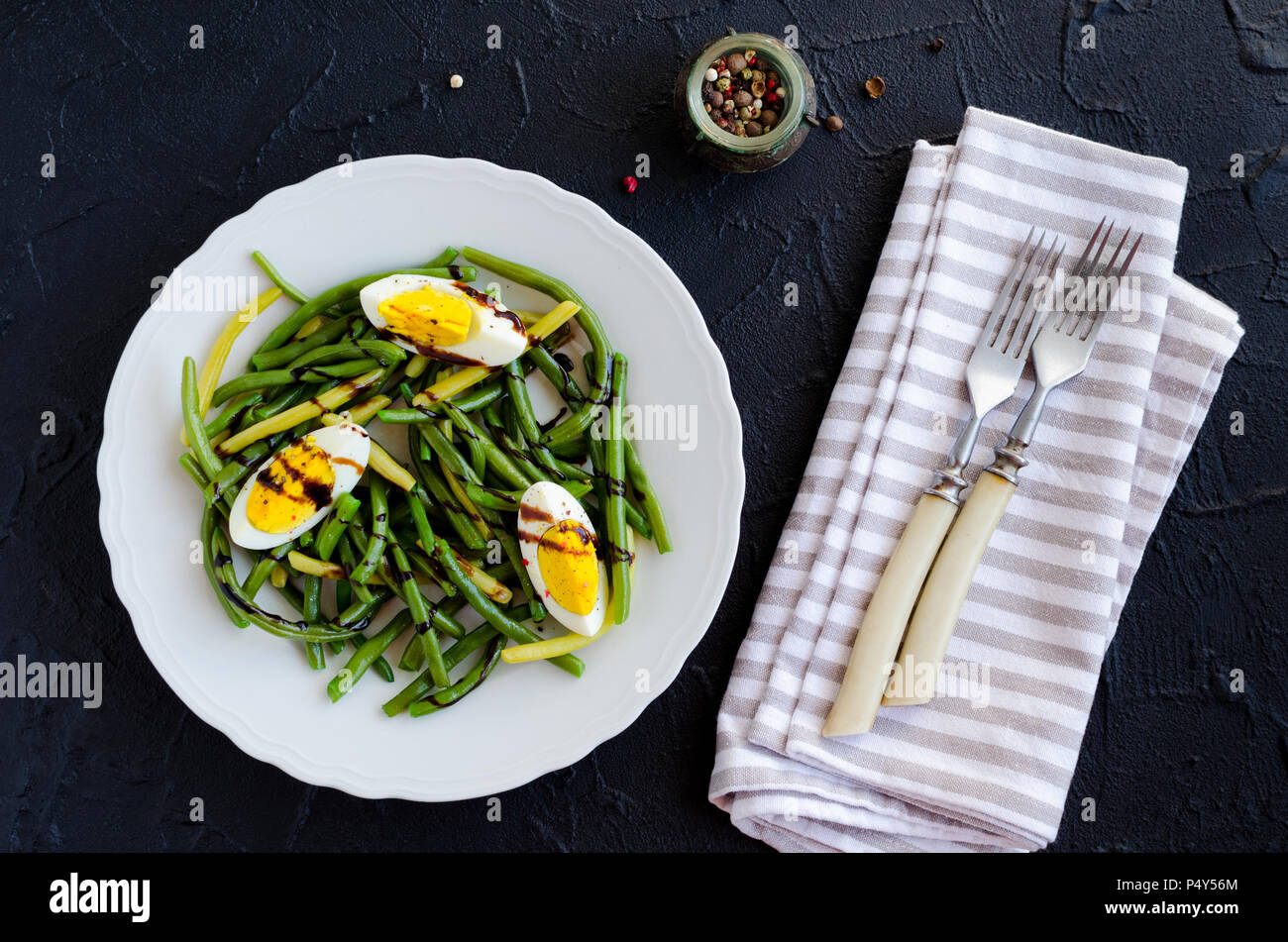 Fresh summer warm salad with cooked green beans with boiled eggs and