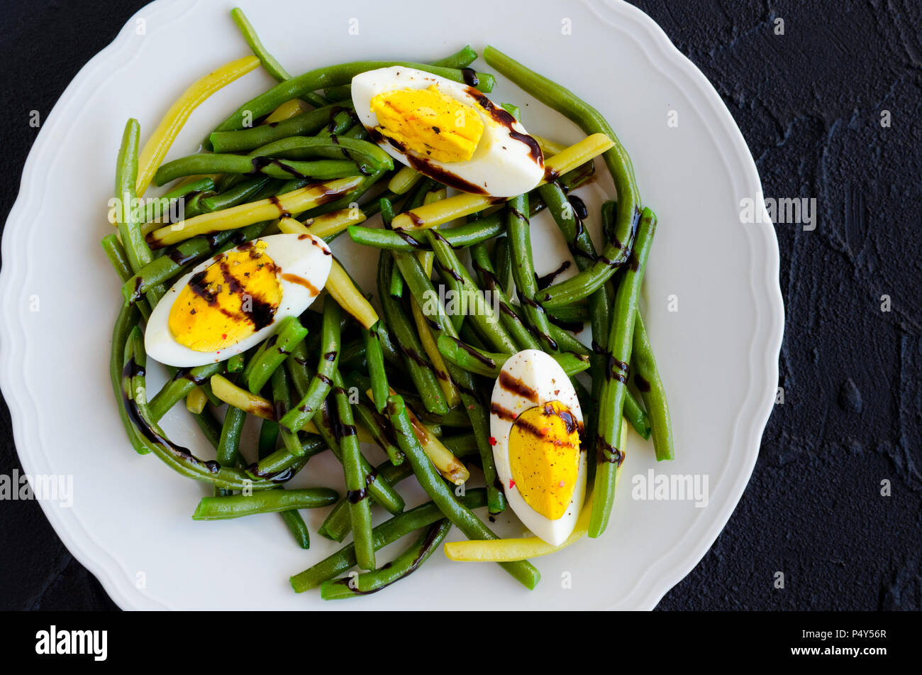 Fresh summer warm salad with cooked green beans with boiled eggs and