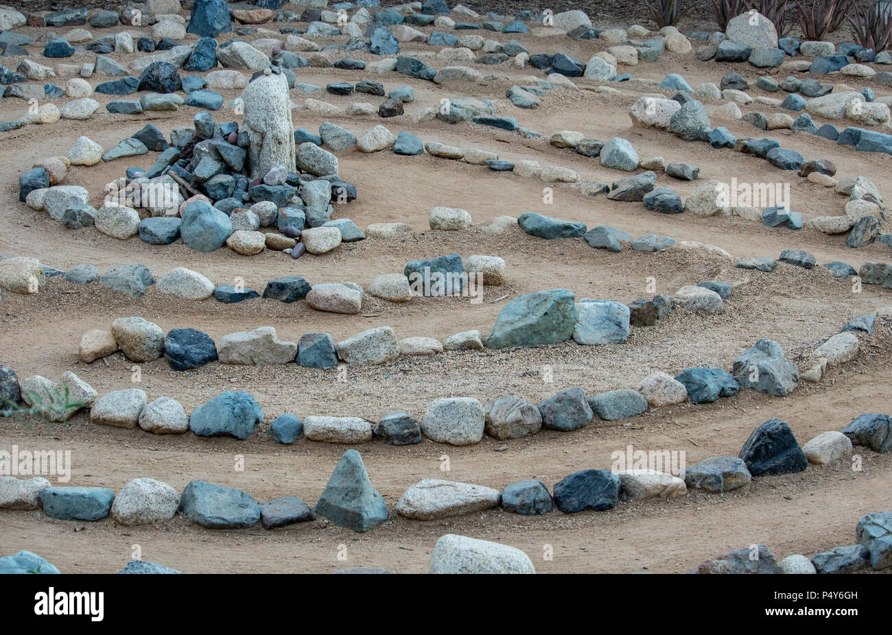 Traditional natural stone walking labyrinth mazze for contemplation and worship, created with rocks in shades of blue and turquoise. A calm, peaceful Stock Photo
